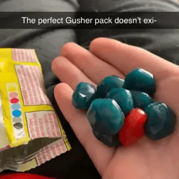 A hand holding all green and one red Gushers that are clumped together, with the text saying, "the perfect Gusher pack doesn't exi-" - Link to social post